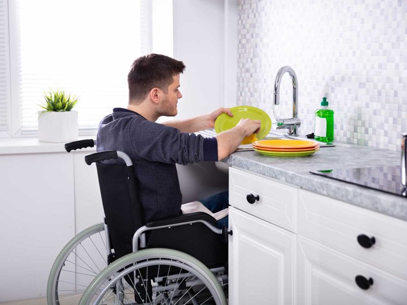 HandicappedManCleaningDishesInKitchen HandicappedManCleaningDishesInKitchen